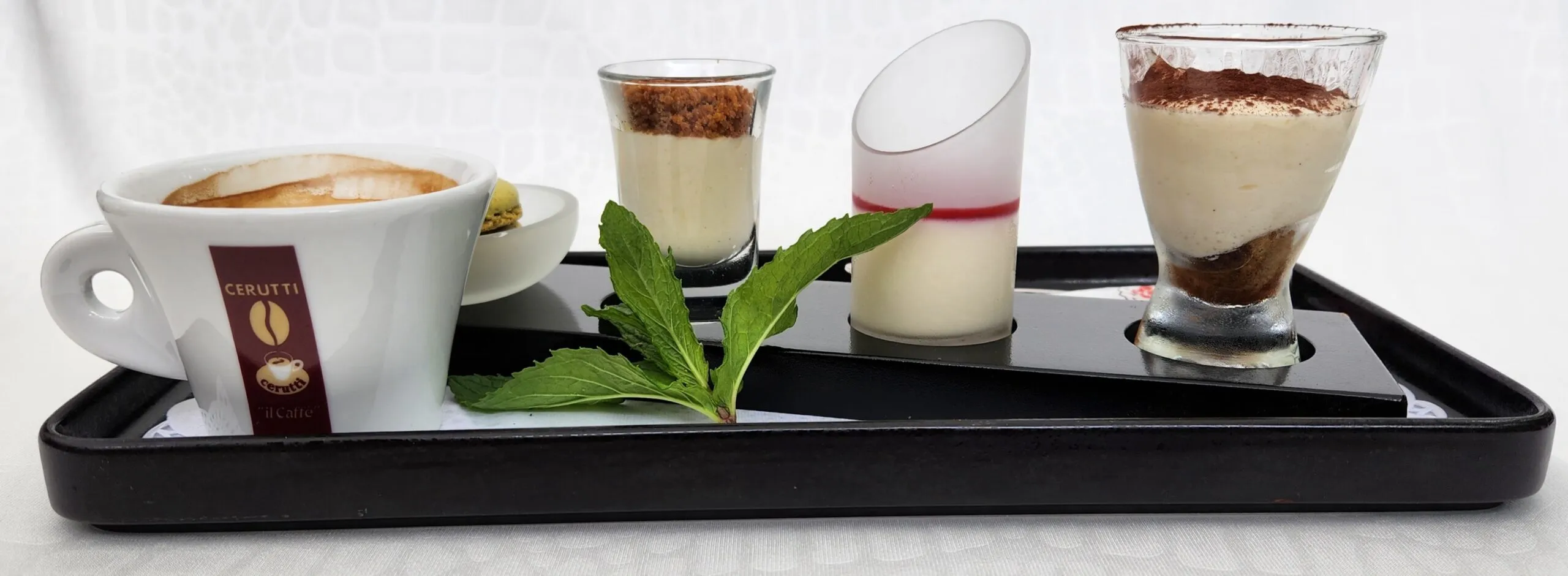 Café gourmand : verrines, tiramisu et panna cotta servis sur un plateau